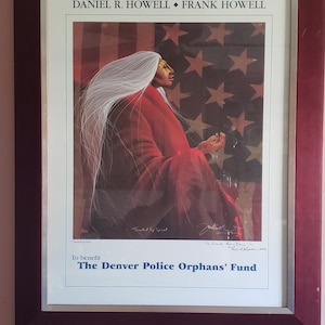 Pode incluir: Impressão emoldurada de uma mulher nativa americana com uma túnica vermelha, cabelo longo e branco, sentada em frente a uma bandeira americana. A impressão é assinada por Frank Howell e diz "Para beneficiar o Fundo de Órfãos da Polícia de Denver".