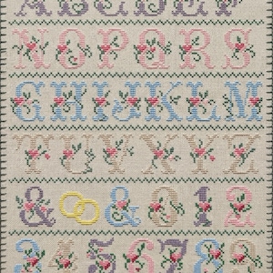 Elegant wedding alphabet cross stitch pattern with floral letters A–Z, digits 0–9, ampersand, hearts, and rings in pastel colors on grid chart for digital PDF download