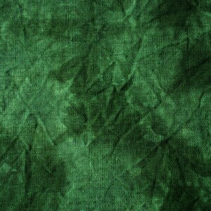 May include: Close-up of a textured, emerald green fabric. The material has a crinkled appearance, with shadows and highlights creating depth. The weave of the fabric is visible, adding to the tactile quality of the image. The overall effect is a rich, deep green.