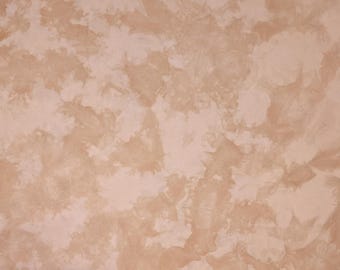 May include: A close-up of a light brown textured wall with a mottled, marbled effect. The wall has a subtle, uneven surface.