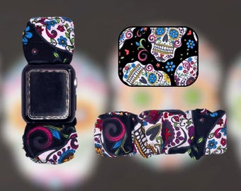 Pulsera con coletero de tela negra con diseño de calavera de azúcar navideña.