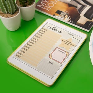 May include: A digital daily planner with a yellow border, featuring a schedule, to-do list, and notes section. The planner includes the text "DAILY PLANNER" and a quote. The image also includes a color swatch and small potted plants.