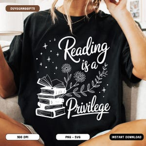 May include: Black t-shirt with a white graphic that reads "Reading is a Privilege." The design includes a stack of books, flowers, leaves, and stars. The shirt is a casual wear item.