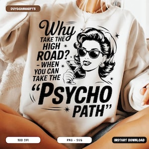 May include: Cream-colored sweatshirt with a black graphic of a woman wearing sunglasses and holding a cocktail. The text reads "Why take the high road? - When you can take the 'Psycho Path'" in a vintage font.