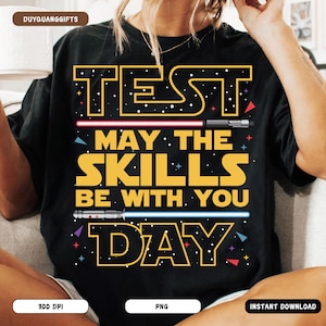 May include: Black t-shirt with a Star Wars themed graphic that says "Test Day. May the skills be with you." The graphic is yellow with a red and blue lightsaber design.
