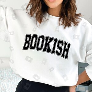 May include: White sweatshirt with black text that reads "BOOKISH" in a vintage collegiate font.