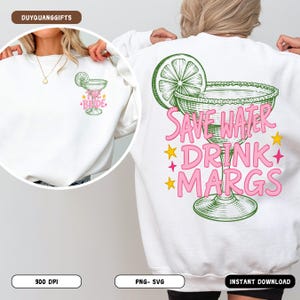 May include: White sweatshirt with a margarita graphic on the back, featuring the text "Save Water Drink Margs" in pink and green. The front has a smaller margarita design with "The Bride" text. A fun, casual top.