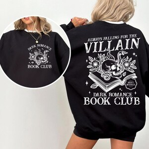 May include: Black sweatshirt with a white skull and snake design and the text "Always falling for the villain. Dark Romance Book Club. Meet weekly." on the back. The front of the sweatshirt has the text "Dark Romance Book Club" with a smaller skull and snake design.