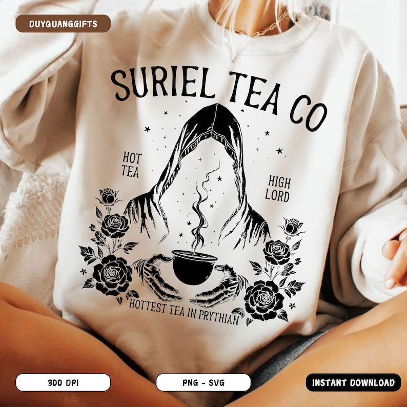 May include: Cream-colored sweatshirt with a black graphic design. The design features the text "SURIEL TEA CO", a hooded figure, roses, and the text "HOTTEST TEA IN PRYTHIAN". The sweatshirt is a cozy, casual garment.