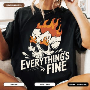Może przedstawiać: Czarny t-shirt z białym motywem czaszki z pomarańczowymi płomieniami i napisem "EVERYTHING'S FINE". Projekt jest graficzną ilustracją. Odzież codzienna.