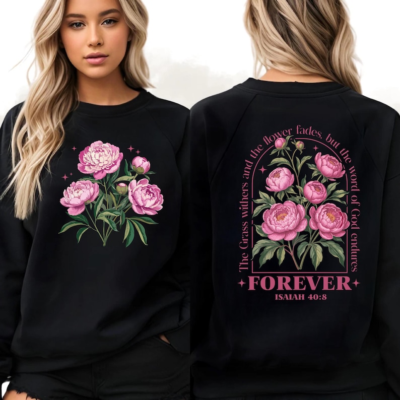 May include: Black sweatshirt featuring a floral design with pink peonies and green leaves. The front of the sweatshirt displays a bouquet of flowers. The back of the sweatshirt has the text "The Grass withers and the flower fades, but the word of God endures" and "FOREVER" with "ISAIAH 40:8".