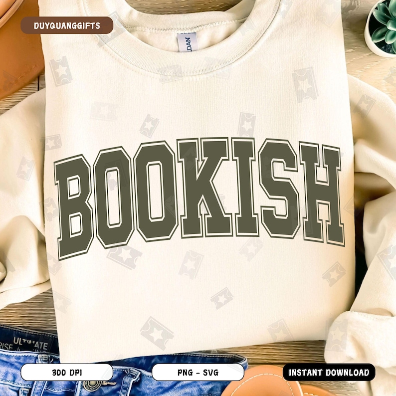 May include: A beige sweatshirt with the word "BOOKISH" printed in dark green letters with a white outline. The letters are in a bold, blocky font.