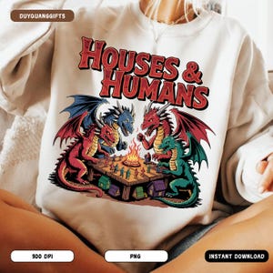 Peut inclure: Sweat-shirt crème avec un motif de dragons jouant à un jeu de société autour d'un feu de camp. Le texte "HOUSES & HUMANS" est en rouge. Les dragons sont rouges, bleus et verts. Vêtement décontracté et confortable.