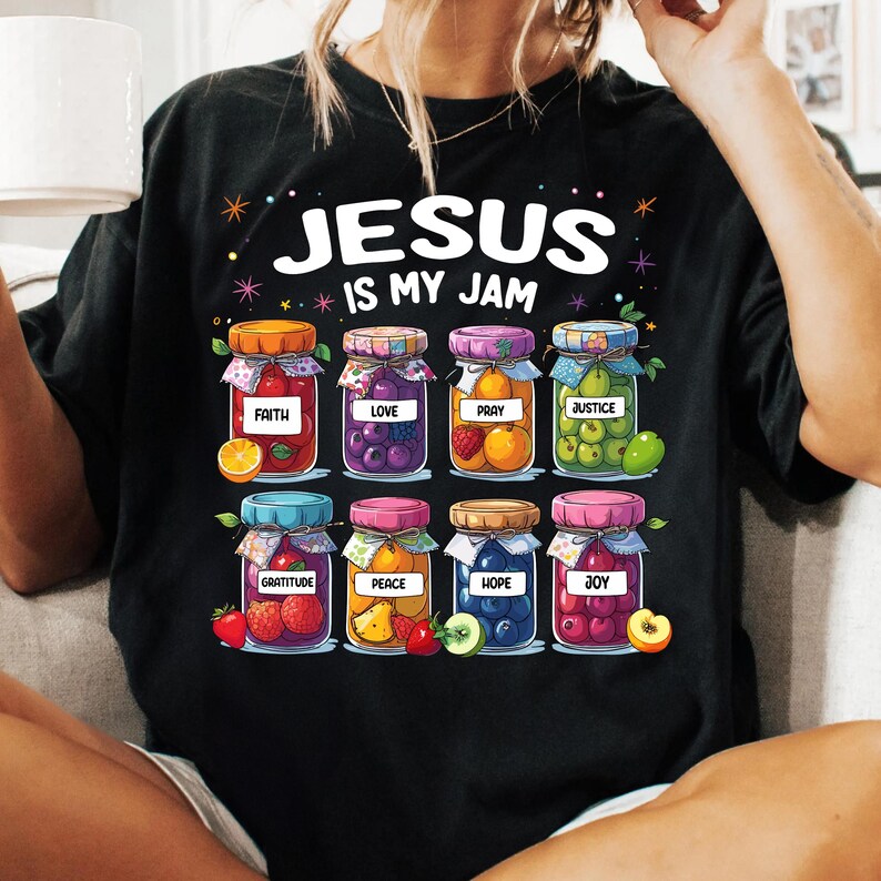 May include: Black t-shirt with the text "Jesus is my jam" and a graphic of jars filled with fruit. The jars are labeled with words like "faith", "love", "pray", "justice", "gratitude", "peace", "hope", and "joy".