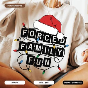 May include: Cream-colored sweatshirt with the text "FORCED FAMILY FUN" in black block letters, adorned with a Santa hat and string lights. The design includes colorful bulbs and is a festive holiday theme.
