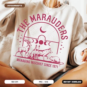 Può includere: Una felpa bianca con un design grafico rosa che dice "The Marauders Managing Mischief Since 1971". La grafica presenta una luna crescente, stelle e quattro animali: un cervo, due lupi e un ratto.
