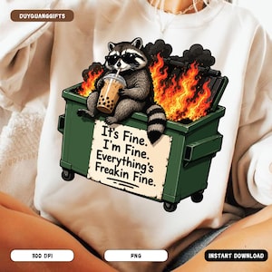 Puede incluir: Sudadera blanca con un diseño humorístico de un mapache con gafas de sol, sentado en un contenedor de basura en llamas, sosteniendo una bebida. El contenedor tiene el texto "It's Fine. I'm Fine. Everything's Freakin Fine."