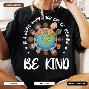 May include: Black t-shirt with the text "In a world where you can be anything, be kind." The shirt features a graphic of a smiling Earth surrounded by diverse children. The design includes stars and floral accents.