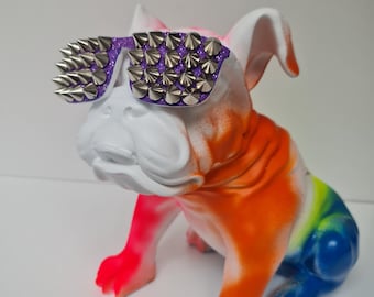 Könnte beinhalten: Eine farbenfrohe Bulldoggenfigur mit lila Sonnenbrille und silbernen Stacheln. Der Bulldogge ist in einem Farbverlauf aus Farben wie Rot, Orange, Gelb, Grün und Blau bemalt. Die Figur ist ein dekorativer Gegenstand.