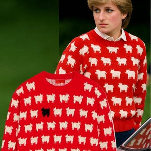 May include: Red sweater featuring a pattern of white sheep, with one black sheep. The sweater is a crew neck style. The image also shows a person wearing the same sweater.