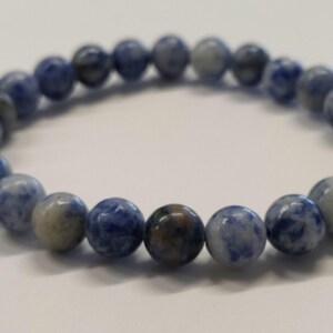 Könnte beinhalten: Ein blaues und weißes Edelstein-Armband mit runden Perlen.