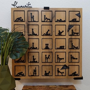 Könnte beinhalten: Ein Holzbrett mit einem Raster aus 25 Quadraten, jedes mit einer schwarzen Silhouette eines Paares in einer anderen Position. Das Brett ist oben mit "Kama Sutra" beschriftet und hat auf einigen Quadraten kleine handschriftliche Notizen.
