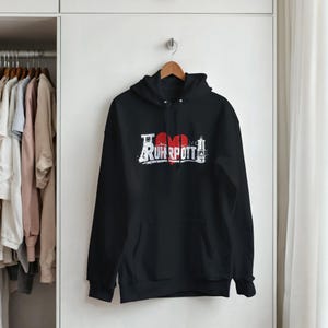 May include: Black hoodie with a front graphic that reads "I Love Ruhrpott" in white and red. The design features a red heart and stylized text. The hoodie has a hood and a front pocket.