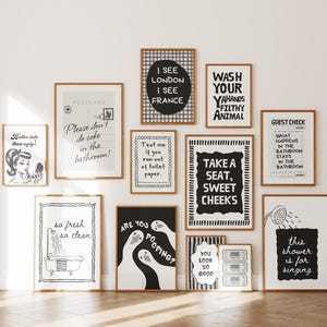 May include: A gallery wall collection of eleven framed black and white prints featuring humorous bathroom-themed text and illustrations, including phrases like Wash Your Hands, Take A Seat, Sweet Cheeks, and Are You Pooping, displayed in wooden frames.