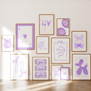 May include: A collection of framed art prints in shades of purple and white. The prints feature various designs, including a playing card, a bikini, a disco ball, a pair of cherries, and the text "I'm literally just a girl".