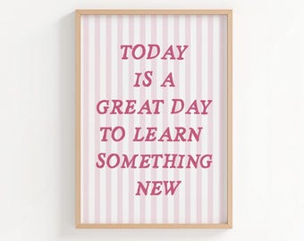 May include: A rectangular wall art print in a light wooden frame featuring vertical light pink and white stripes. The text "TODAY IS A GREAT DAY TO LEARN SOMETHING NEW" is printed in a bold, dark pink serif font centered on the striped background.