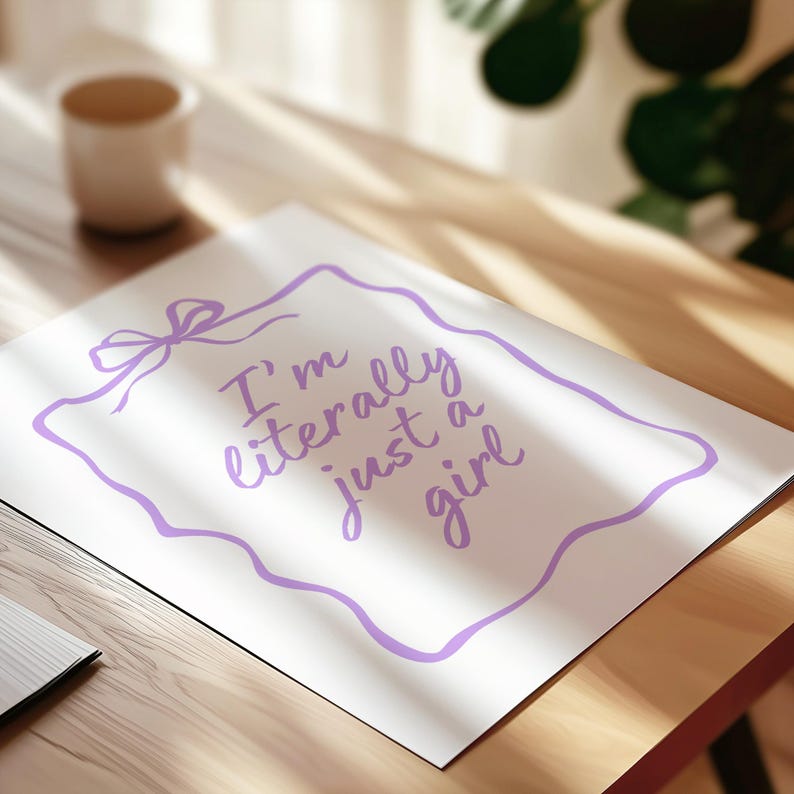May include: A white rectangular print featuring a light purple hand-drawn style border with a bow at the top left corner. The text "I'm literally just a girl" is printed in the center in a matching light purple cursive script font.