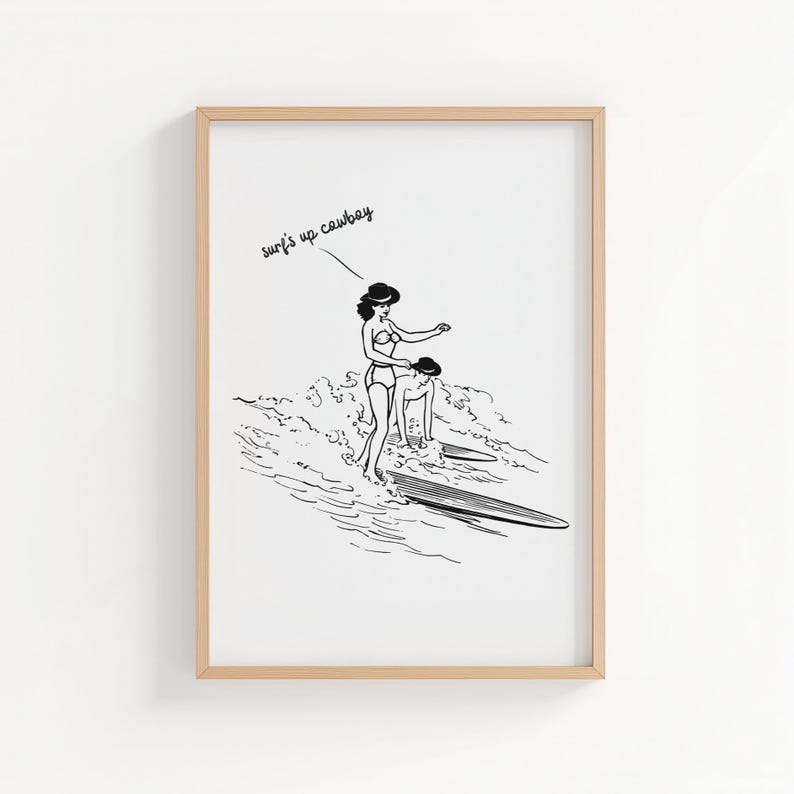 May include: Black and white illustration of two people surfing. One person is standing on a surfboard, while the other is in the water. The text "surf's up cowboy" is written above the figures.
