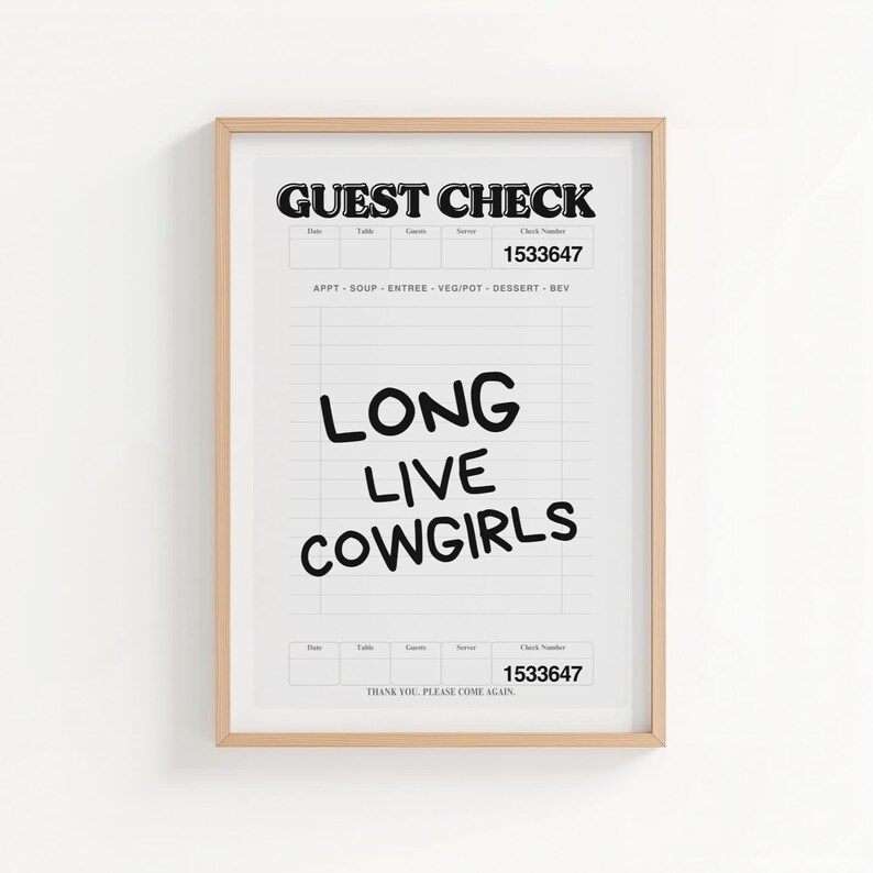 May include: A framed print featuring a stylized "Guest Check" design. Bold black text at the top reads "GUEST CHECK" and "1533647". Below, the words "LONG LIVE COWGIRLS" are written in a playful font. The print is in a light wood frame.