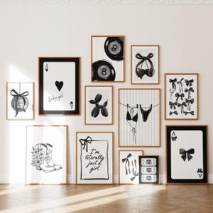 Puede incluir: Una colección de impresiones artísticas en blanco y negro enmarcadas. Las impresiones presentan varios diseños, incluyendo naipes, lazos, un animal de globo y texto que dice "Lucky girl" y "I'm literally just a girl".