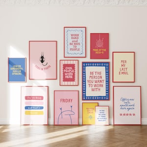 May include: A collection of twelve rectangular wall art prints in red frames featuring various office-themed slogans and illustrations, including text like Work Hard, Panic at the Desk, Per My Last Email, and Friday, displayed on a plain wall.
