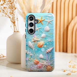 May include: A blue phone case with a seashell and starfish design. The case has a cutout for the camera lens and a white background.
