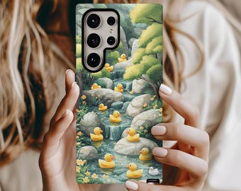 May include: A phone case with a colorful illustration of a stream with yellow rubber ducks floating down it. The case has a camera cutout and a green background.