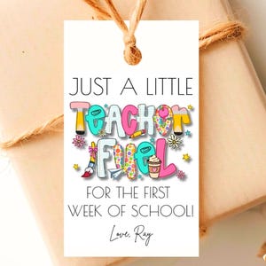 Puede incluir: Una etiqueta de regalo con el texto "JUST A LITTLE TEACHER FUEL FOR THE FIRST WEEK OF SCHOOL! Love, Ray." La etiqueta tiene un diseño colorido con lápices, flores y una taza de café. La etiqueta está atada a un regalo envuelto con hilo.