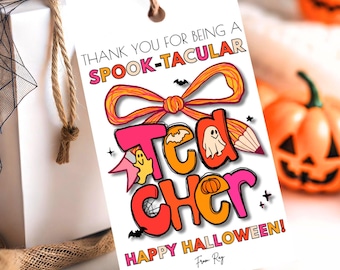 Può includere: Un'etichetta regalo bianca a tema Halloween. L'etichetta recita "THANK YOU FOR BEING A SPOOK-TACULAR TEACHER! HAPPY HALLOWEEN!" in lettere arancioni, rosa e nere. Sono presenti anche un fiocco decorativo e illustrazioni a tema Halloween.