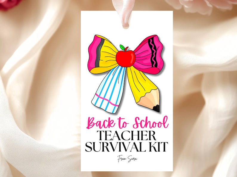 May include: A white gift tag featuring a colourful illustration of a bow made from a pencil and a crayon, topped with a red apple. The tag reads "Back to School Teacher Survival Kit" in pink and black text.