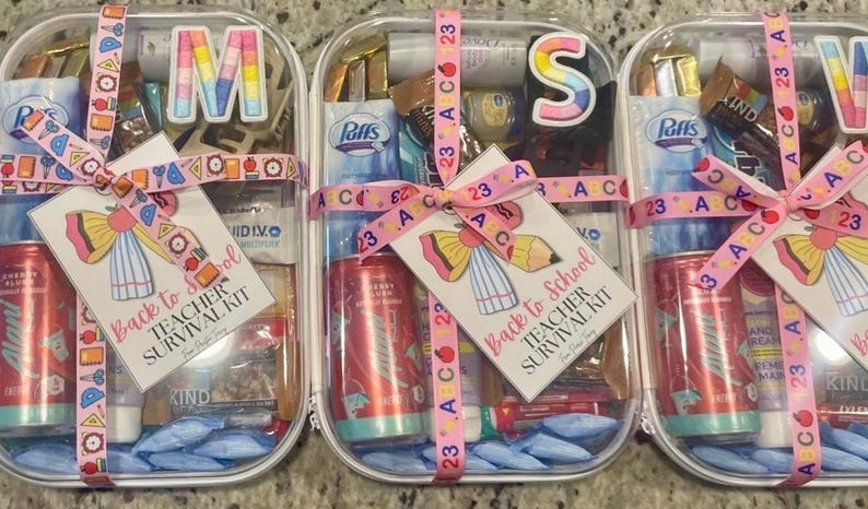 May include: Three clear plastic containers, each a 'Back to School Teacher Survival Kit', filled with items like a red soda can, snacks, and tissues. The kits are tied with pink ribbons and tags. The kits are designed to help teachers.