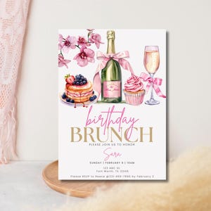 Pode incluir: Um convite para um brunch de anivers&aacute;rio rosa e dourado com uma ilustra&ccedil;&atilde;o em aquarela de uma ta&ccedil;a de champanhe, uma garrafa de champanhe, um cupcake e um prato de panquecas com frutas vermelhas. O texto diz "brunch de anivers&aacute;rio" e "Por favor, junte-se a n&oacute;s para homenagear Sara".