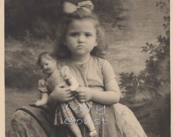 Pouty little girl with doll and bow sepia photo digital download ephemera.