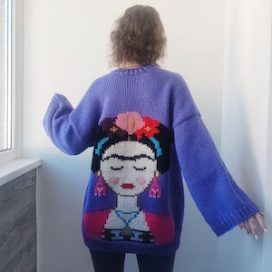 May include: Purple knitted jumper with a colourful embroidered image of Frida Kahlo on the back.