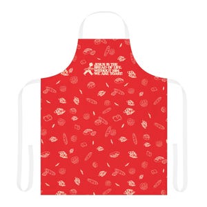 May include: Red apron with white straps and a repeating pattern of bread illustrations. The apron features the text "JESUS IS THE BREAD OF LIFE. WITHOUT HIM WE ARE TOAST!" in white. A fun and functional kitchen accessory.