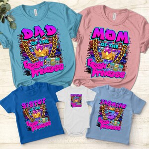 May include: A set of five t-shirts featuring a graffiti-style design with the words "Fresh Princess" and a crown. The shirts are in different colors and sizes, with the text "Dad of the Fresh Princess", "Mom of the Fresh Princess", "Sister of the Fresh Princess", "Jazmine 3 Fresh Princess", and "Fresh Princess" on each shirt.