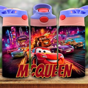 Puede incluir: Una botella de agua colorida con personajes de la película Cars. La botella tiene una tapa roja con botón, un asa azul y un diseño con la palabra "McQueen". El fondo muestra una escena de la ciudad con coches.