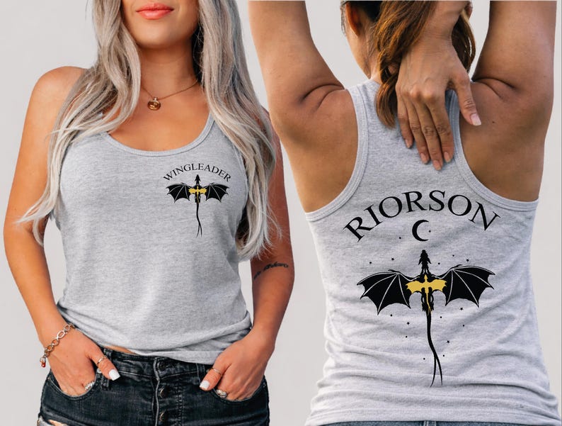 A woman wearing a grey tank top with a dragon design and the text "WINGLEADERRIOR C" printed on it.