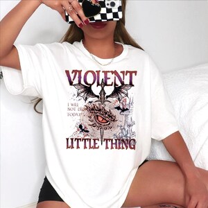 A woman wearing a white t-shirt with a graphic design and text printed on it.