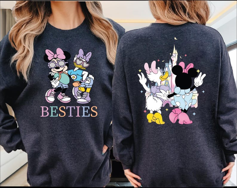 two people wearing matching sweatshirts with a cartoon character design.